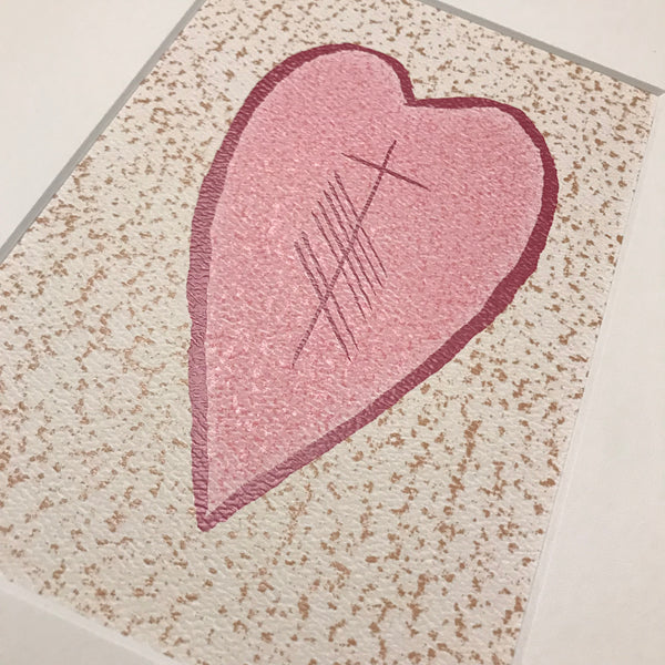 Close up of pink heart with Ogham writing in the middle